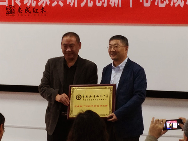 中南林业科技大学副院长刘元（左）为志成红木总经理汤朝阳（右）颁牌