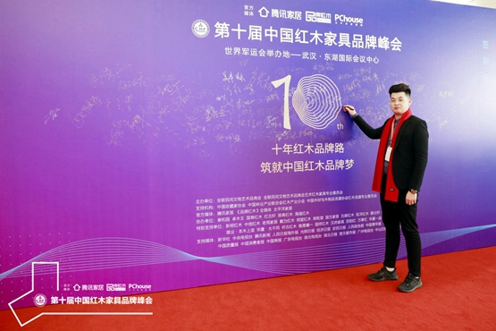 志成红木副总经理陈嘉诚在红木家具品牌峰会签到板上签字，与全国各地行业精英共话红木新发展